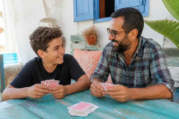Kısa siyah saçlı, gür sakallı, kaplumbağa kabuğu gözlüklü ve ekose gömlekli bir psikolog ile kıvırcık saçlı on üç yaşında bir genç sohbet ederken birlikte kâğıt oyunu oynuyor; ikisi de gülümsüyor